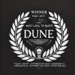 A classic laurel wreath design often seen in movie trailers or posters, symbolizing an award. The laurel wreath is elegant and minimalist, with leaves forming a semi-circular arc around the text. In the center of the wreath there is the text: 'WINNER' (at the top) and 'Most Likely to Quote Dune' (at the bottom) in a sophisticated, bold, serif font. Below that, is added the name 'Year 10191 Arrakis Appreciation Conference' in a smaller, modern, sans-serif font. The entire design is black and white, suitable for placement over a movie poster or video. The overall style evokes prestige and professionalism. The award was given at an annual event.